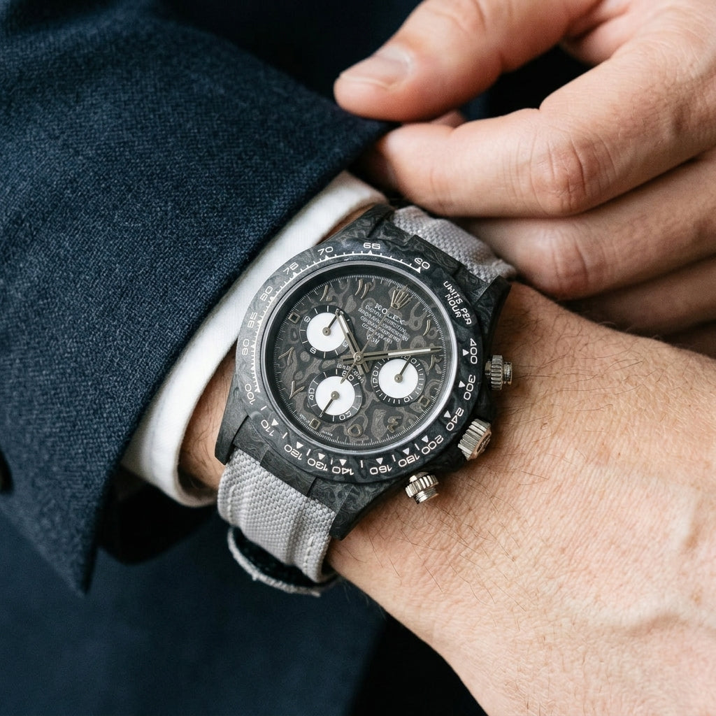 Black forged-carbon chronograph with steel Eastern Arabic numerals on the wrist as a shirt cuff is fastened