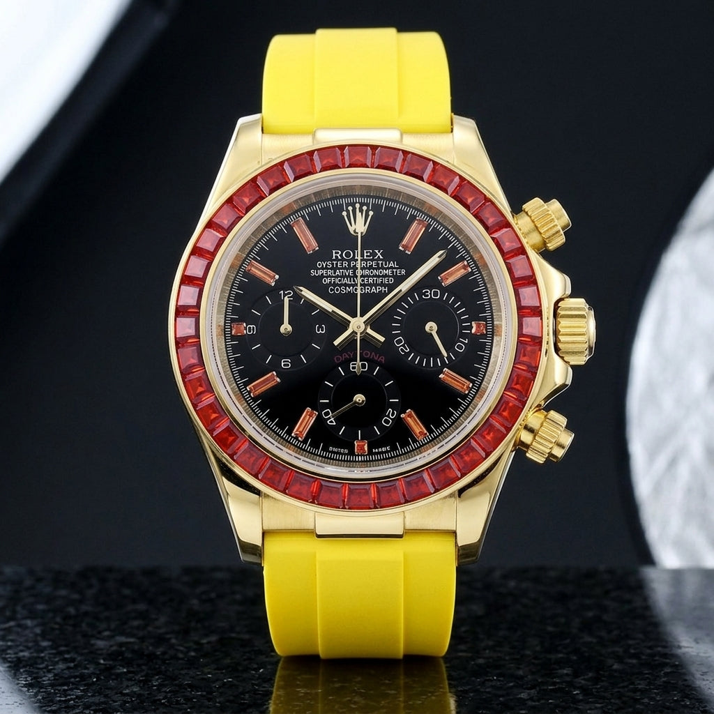 Gold-tone chronograph with a red stone bezel on its yellow rubber strap, worn on the wrist below a dark suit cuff