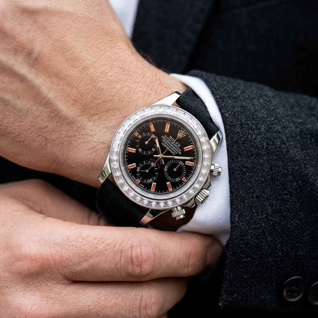 Steel chronograph with a black dial and orange stone markers on the wrist as a shirt cuff is fastened