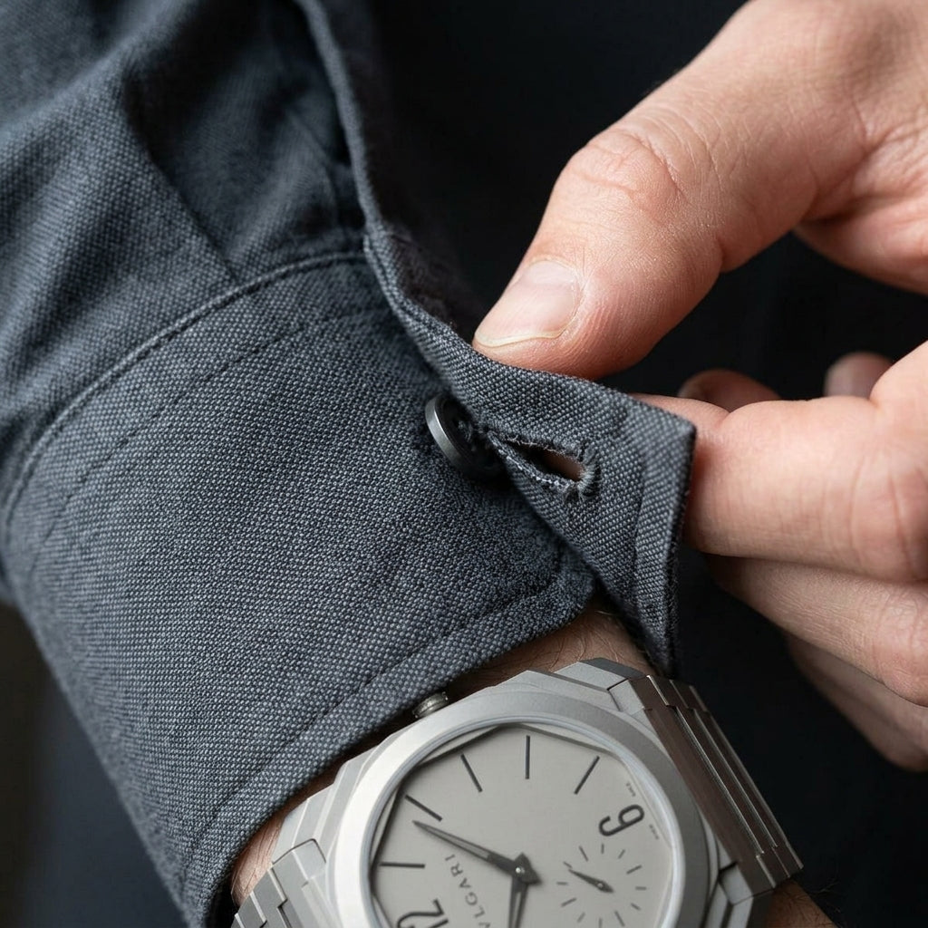 Ultra-thin sandblasted titanium octagonal watch on the wrist as a shirt cuff is fastened