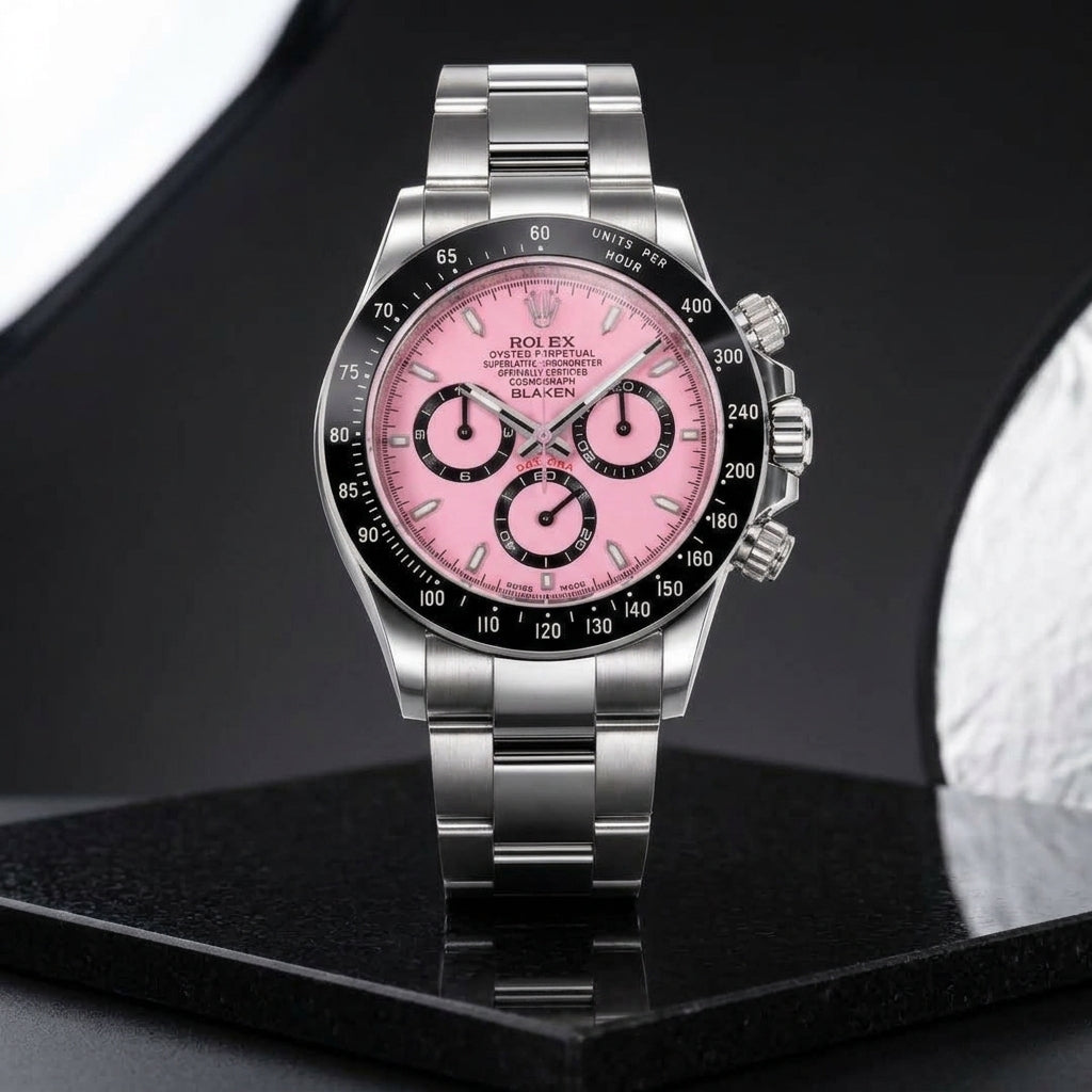 Pink-dial steel chronograph worn under a grey suit cuff