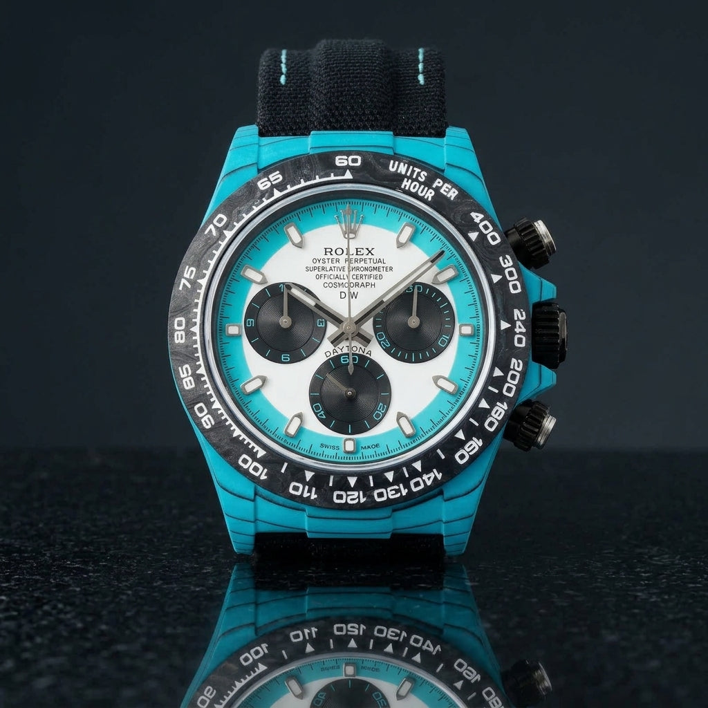 Turquoise-cased chronograph on a black woven strap with turquoise stitching, worn under a cuff