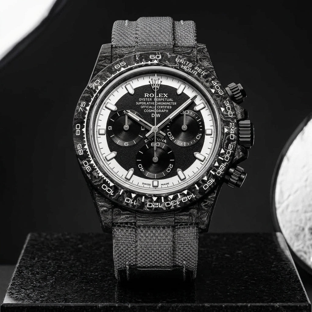 Forged-carbon chronograph on a grey woven strap, worn under a cuff