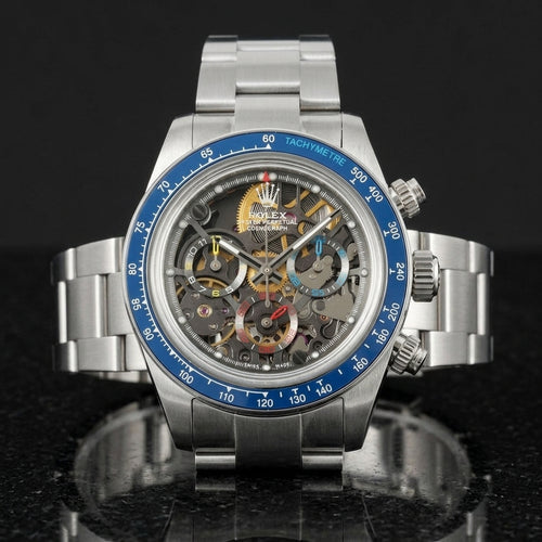 Steel skeleton chronograph with a glossy blue tachymetre bezel, upright on polished black granite