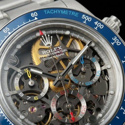 Macro of the open skeleton dial with gold wheels and yellow, red and blue counters under the blue bezel