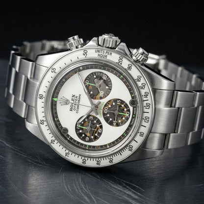 Steel chronograph at a three-quarter angle, the white tachymeter bezel and the steel crown and pushers in view