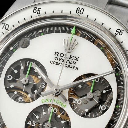 Macro of the white sapphire dial with open skeleton counters, green counter hands and a green-tipped chronograph hand