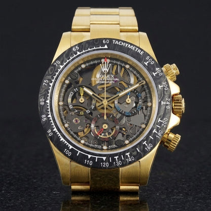 Yellow gold skeleton chronograph with a black marbled bezel, upright on polished black granite