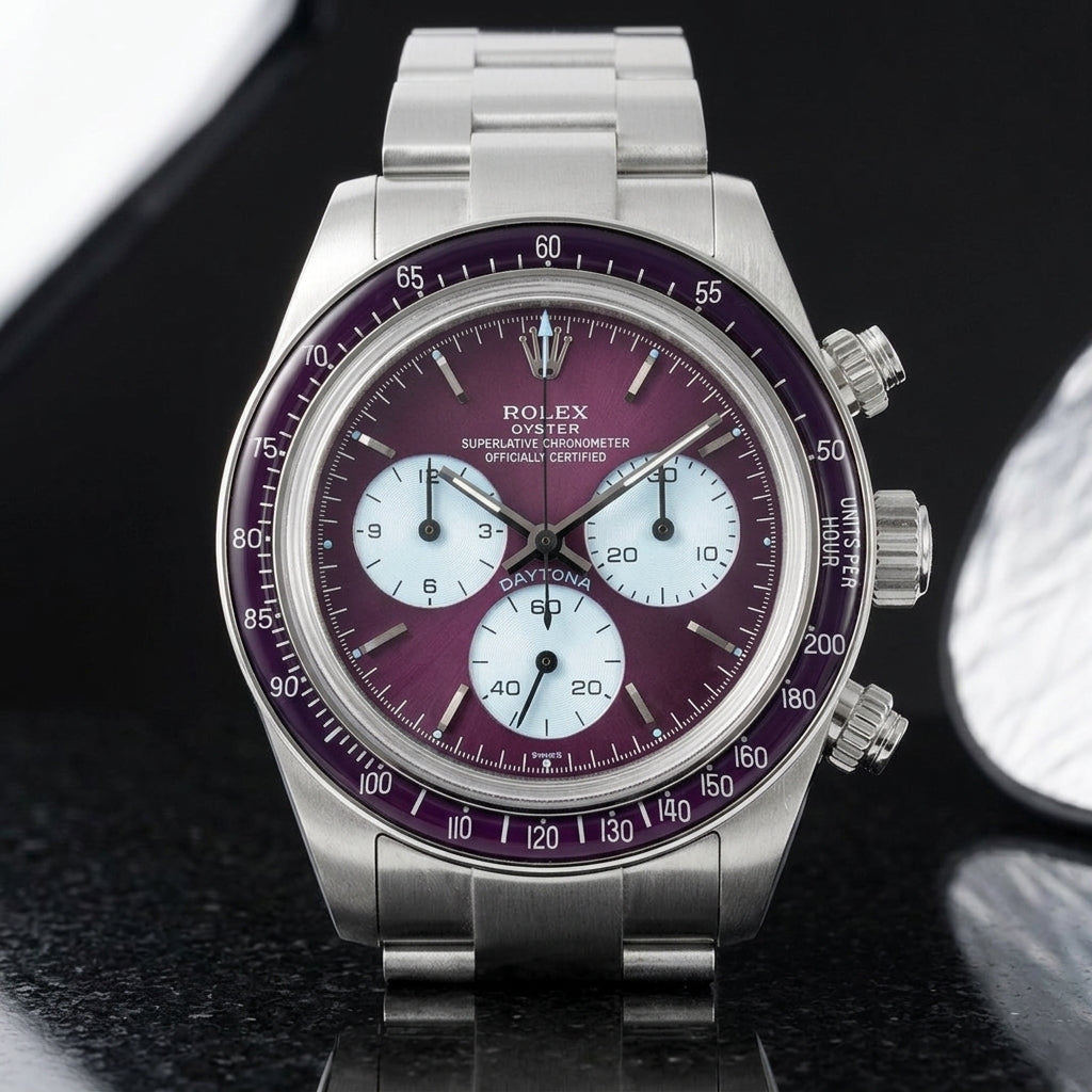 Steel chronograph with a plum-purple dial, ice-blue counters and a plum bezel, upright on polished black granite