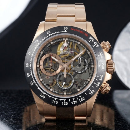 Rose gold skeleton chronograph on its rose gold bracelet, worn on the wrist below a dark suit cuff