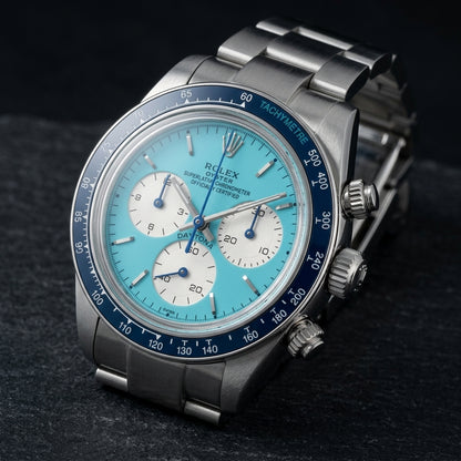 Steel chronograph at a three-quarter angle, the navy tachymeter bezel beside the fluted crown and steel pushers