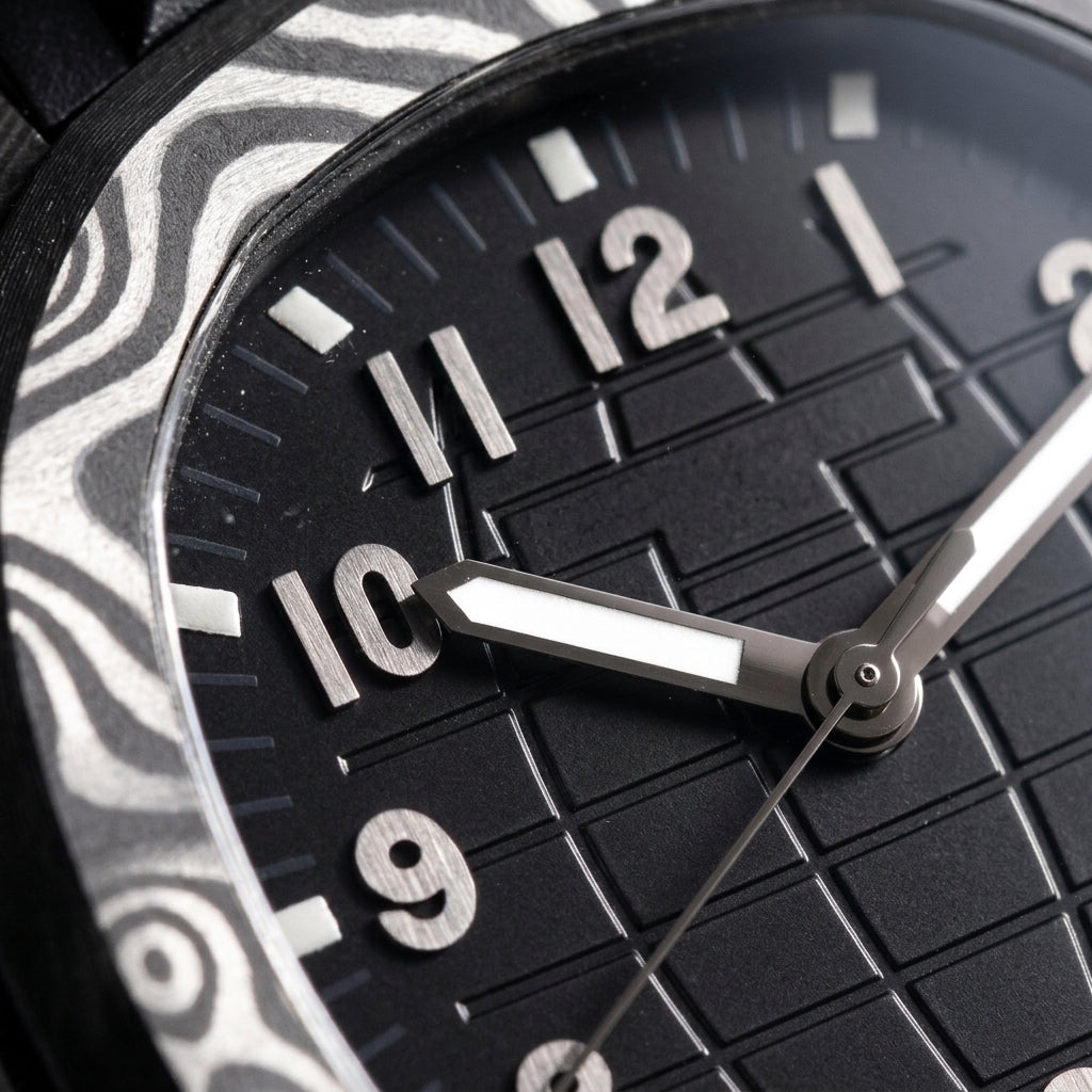 Macro of the black grid dial with applied gunmetal-grey numerals, white luminous markers and the date at three