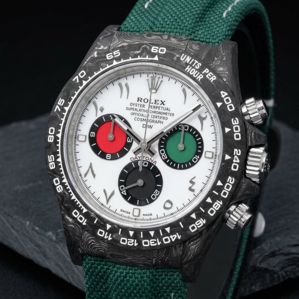 Forged-carbon chronograph with a white dial at a three-quarter angle on dark slate