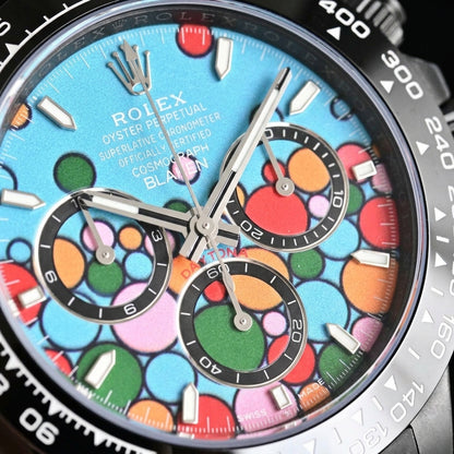 Macro of the turquoise dial, navy-outlined circles in red, orange, dark green, pink and pale blue under polished steel hands