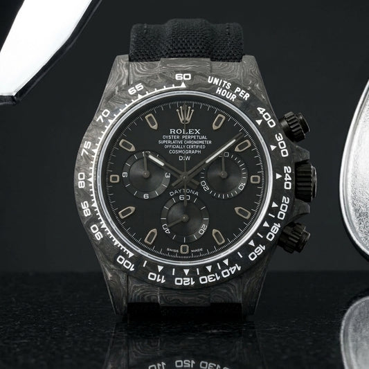 All-black forged-carbon chronograph with a matte black dial on dark stone