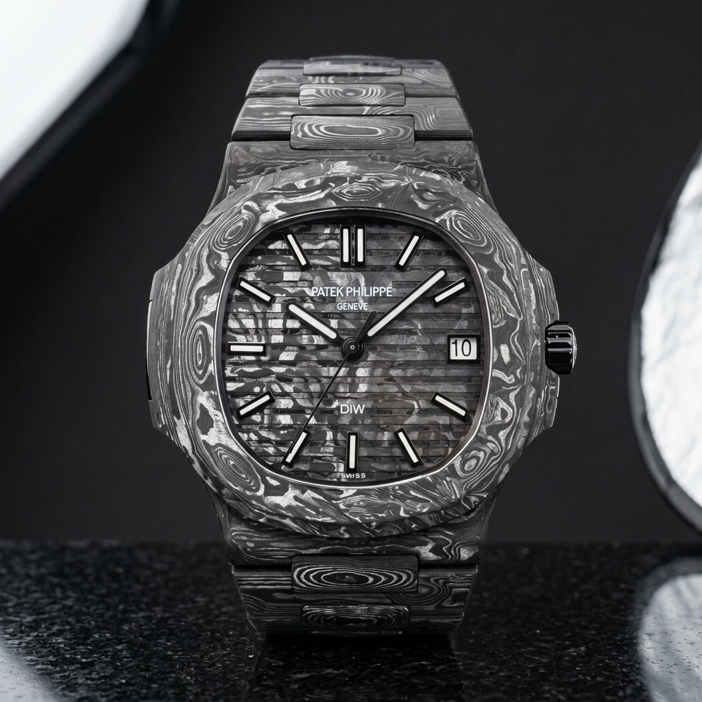 Carbon-dial sports watch on its marbled black and silver-white carbon bracelet, worn on the wrist below a navy suit cuff