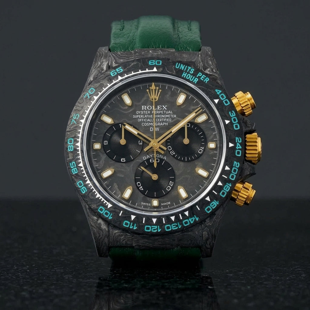 Forged-carbon chronograph on a dark green leather strap, worn under a cuff
