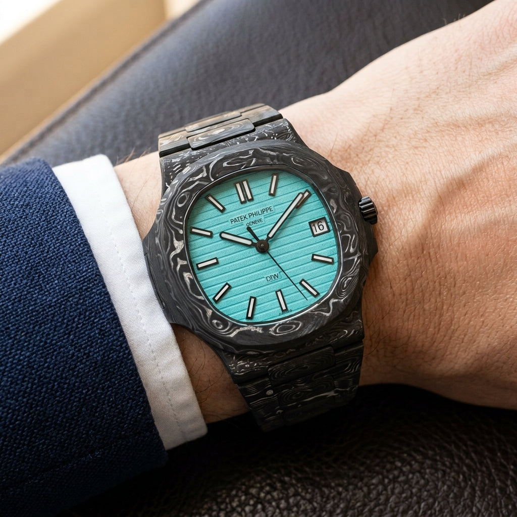 Carbon sports watch with a turquoise dial worn under a navy suit cuff