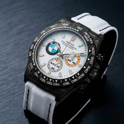 Black forged-carbon chronograph at a three-quarter angle on dark slate