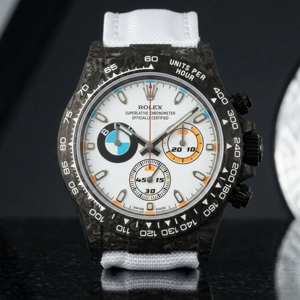 Black forged-carbon chronograph on a white strap worn under a suit cuff