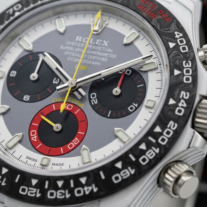 Macro of the grey and white dial inside the black marbled bezel, the red counter and yellow chronograph hand