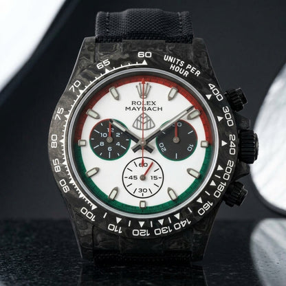Black forged-carbon chronograph on a black strap worn under a suit cuff