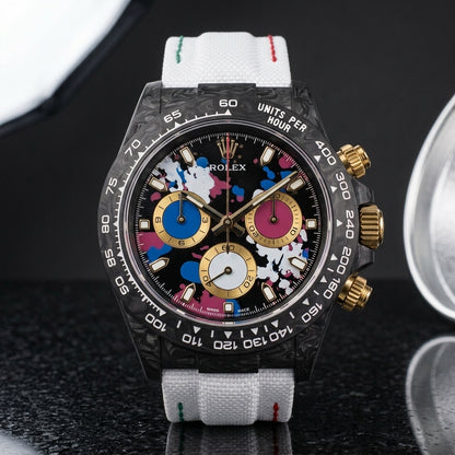 Black forged-carbon chronograph with a paint-splash dial on black granite
