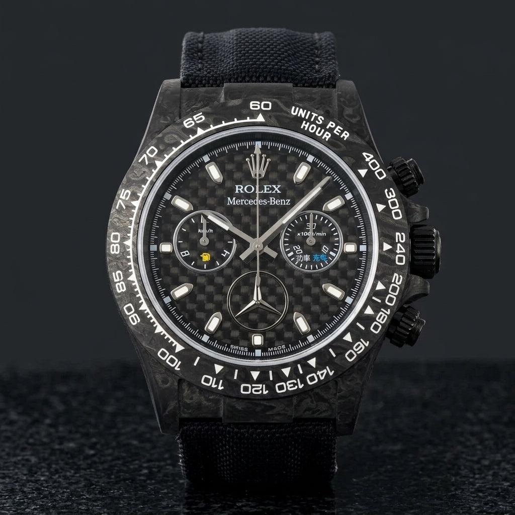 Black forged carbon chronograph with a woven carbon-fibre dial and a three-pointed star emblem, upright on polished black granite