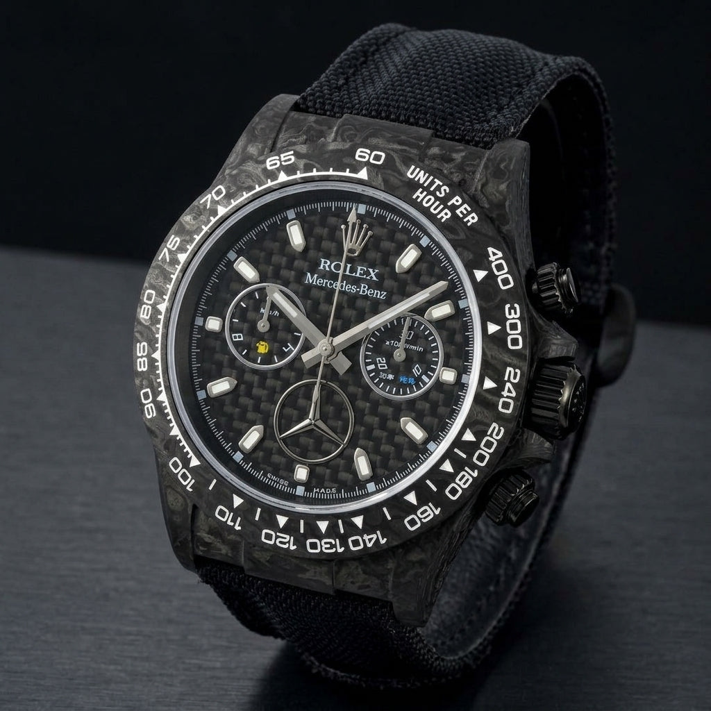 Black forged carbon chronograph at a three-quarter angle on dark slate, grey marbling across its case and bezel