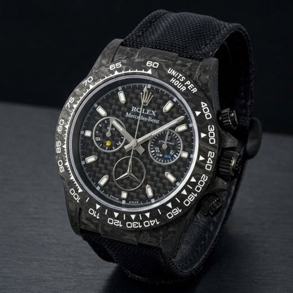 Black forged carbon chronograph at a three-quarter angle on dark slate, grey marbling across its case and bezel