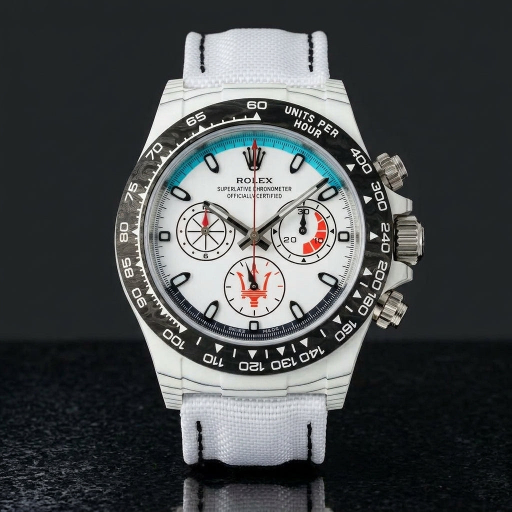White forged-carbon chronograph with a turquoise dial arc on black granite