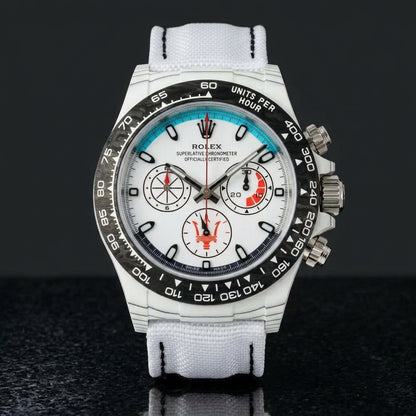 White forged-carbon chronograph with a turquoise dial arc on black granite