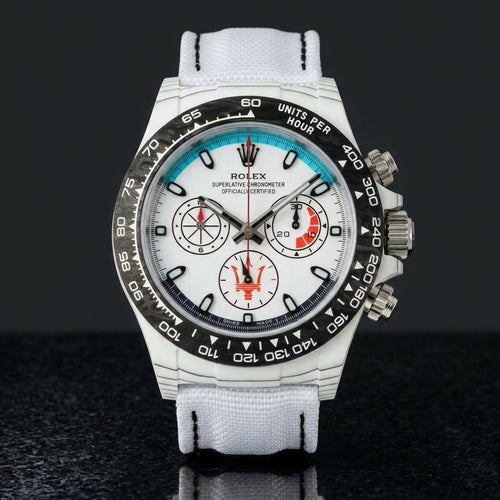 White forged-carbon chronograph with a turquoise dial arc on black granite