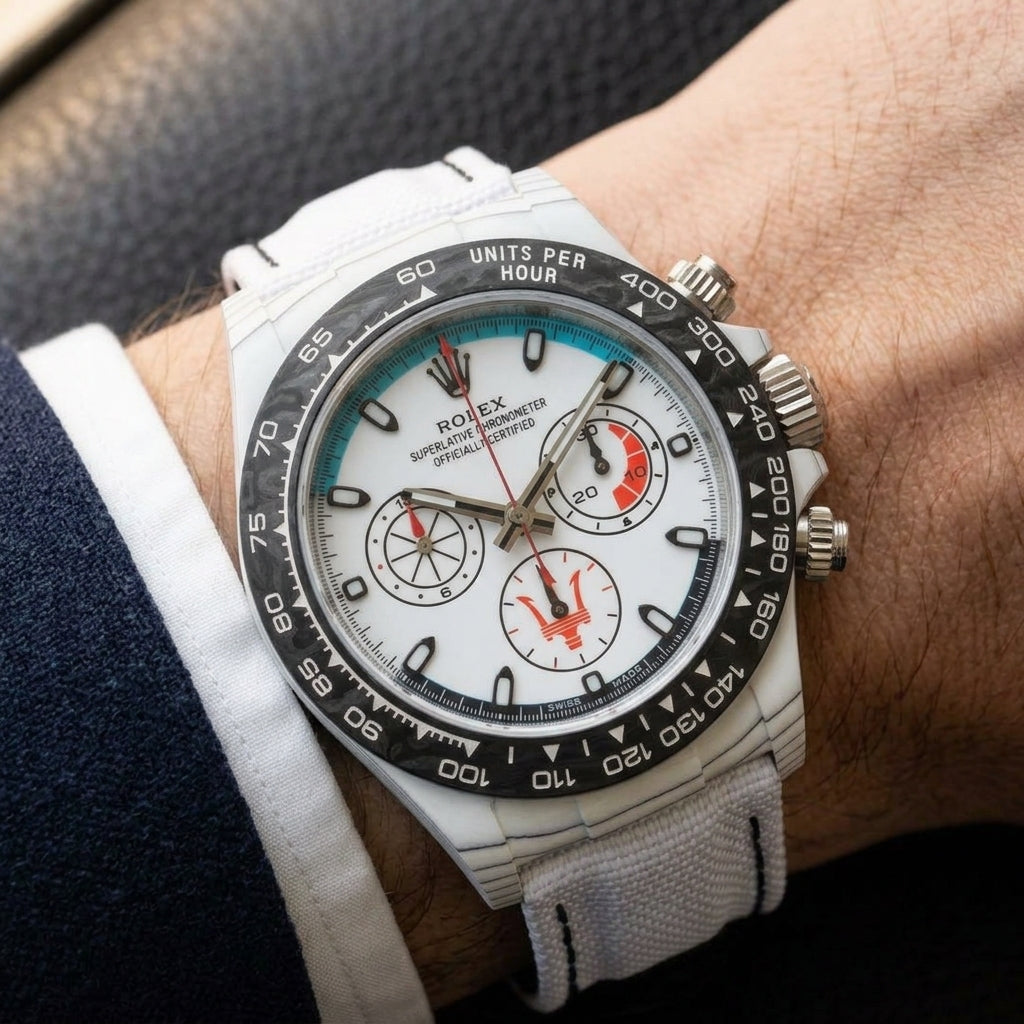 White forged-carbon chronograph on a white strap worn under a suit cuff
