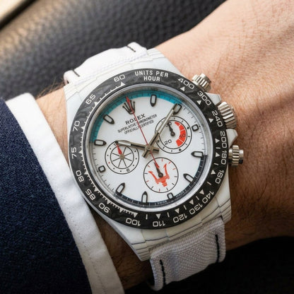 White forged-carbon chronograph on a white strap worn under a suit cuff