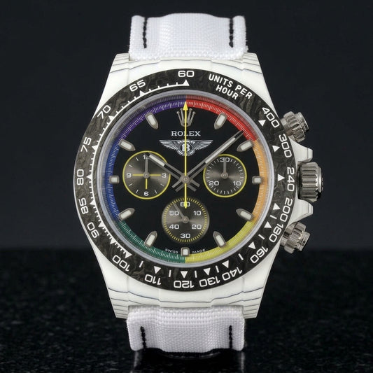 White forged carbon chronograph with a black bezel and a glossy black dial ringed in rainbow colours, upright on polished black granite