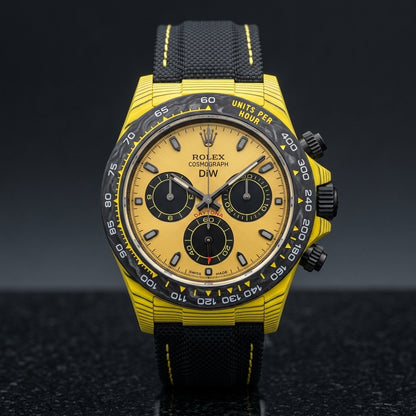 Yellow forged carbon chronograph with a black carbon bezel and a yellow dial with three black counters, upright on polished black granite