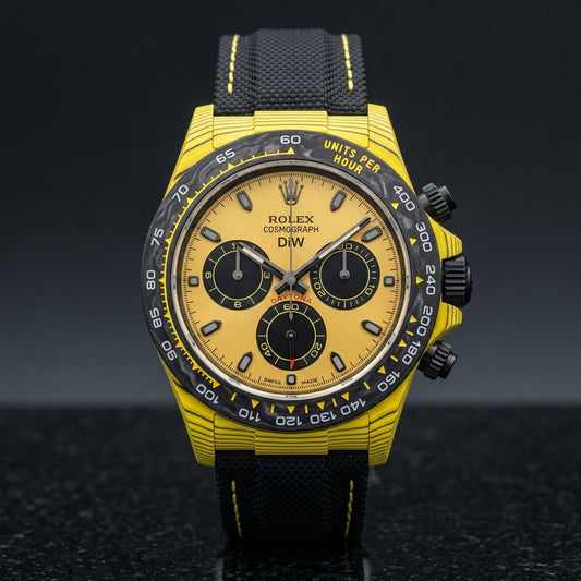 Yellow forged carbon chronograph with a black carbon bezel and a yellow dial with three black counters, upright on polished black granite