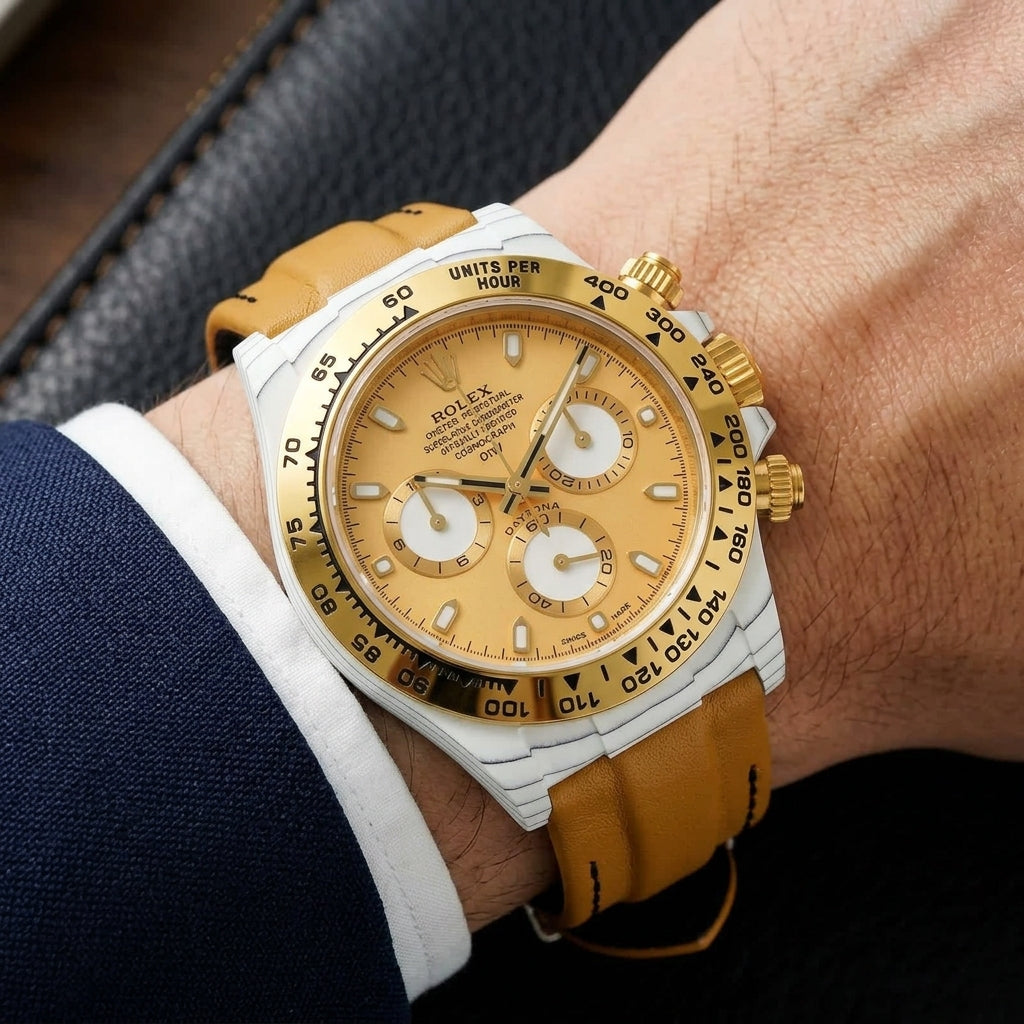 White-cased chronograph on a tan leather strap, worn under a cuff