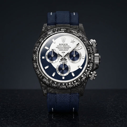 Forged-carbon chronograph with a white and navy dial and a star at twelve, on dark stone