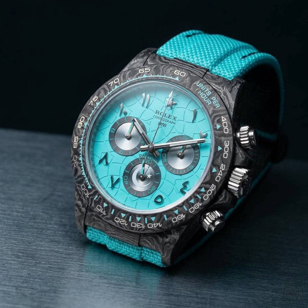 Forged-carbon chronograph at a three-quarter angle, turquoise bezel triangles and turquoise strap visible