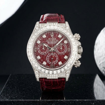 White gold chronograph with a red stone dial and baguette bezel on black granite