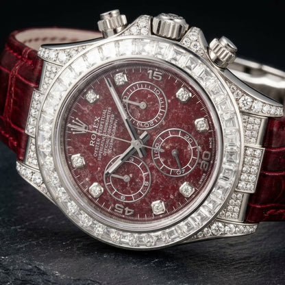 White gold chronograph at a three-quarter angle on dark slate