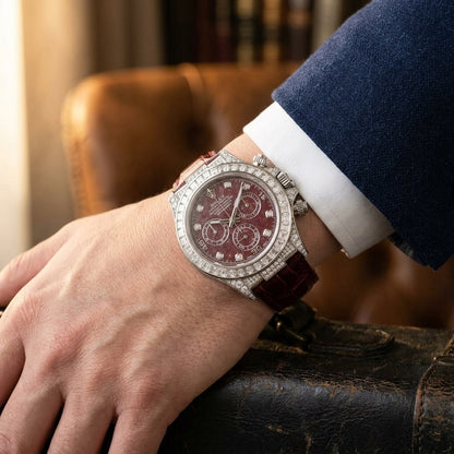 White gold chronograph with a red dial worn under a navy suit cuff