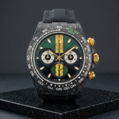 Forged carbon racing chronograph with green dial and gold stripe on black granite