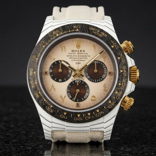 White carbon chronograph with a cream dial, gold Eastern Arabic numerals and a black carbon bezel, upright on polished black granite