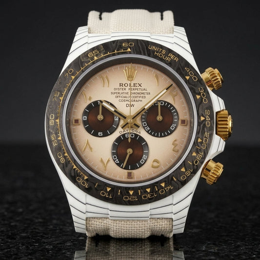 White carbon chronograph with a cream dial, gold Eastern Arabic numerals and a black carbon bezel, upright on polished black granite