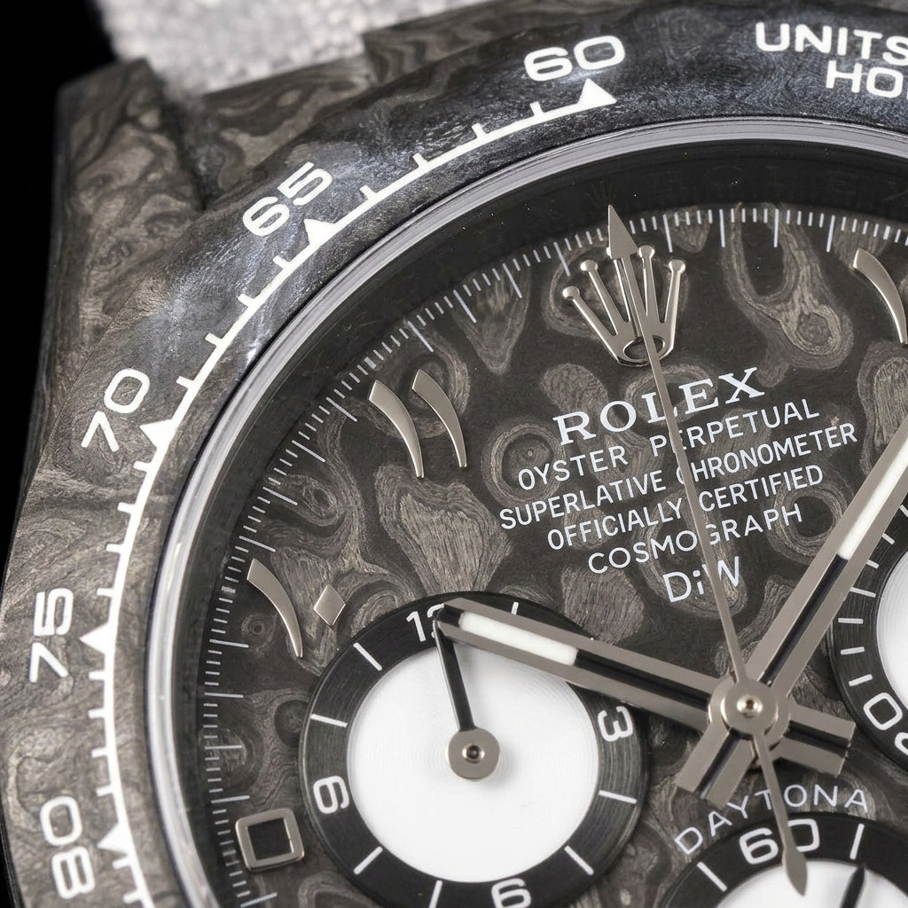 Macro of the grey forged-carbon dial with polished steel Eastern Arabic numerals and three white counters inside the white-printed carbon bezel