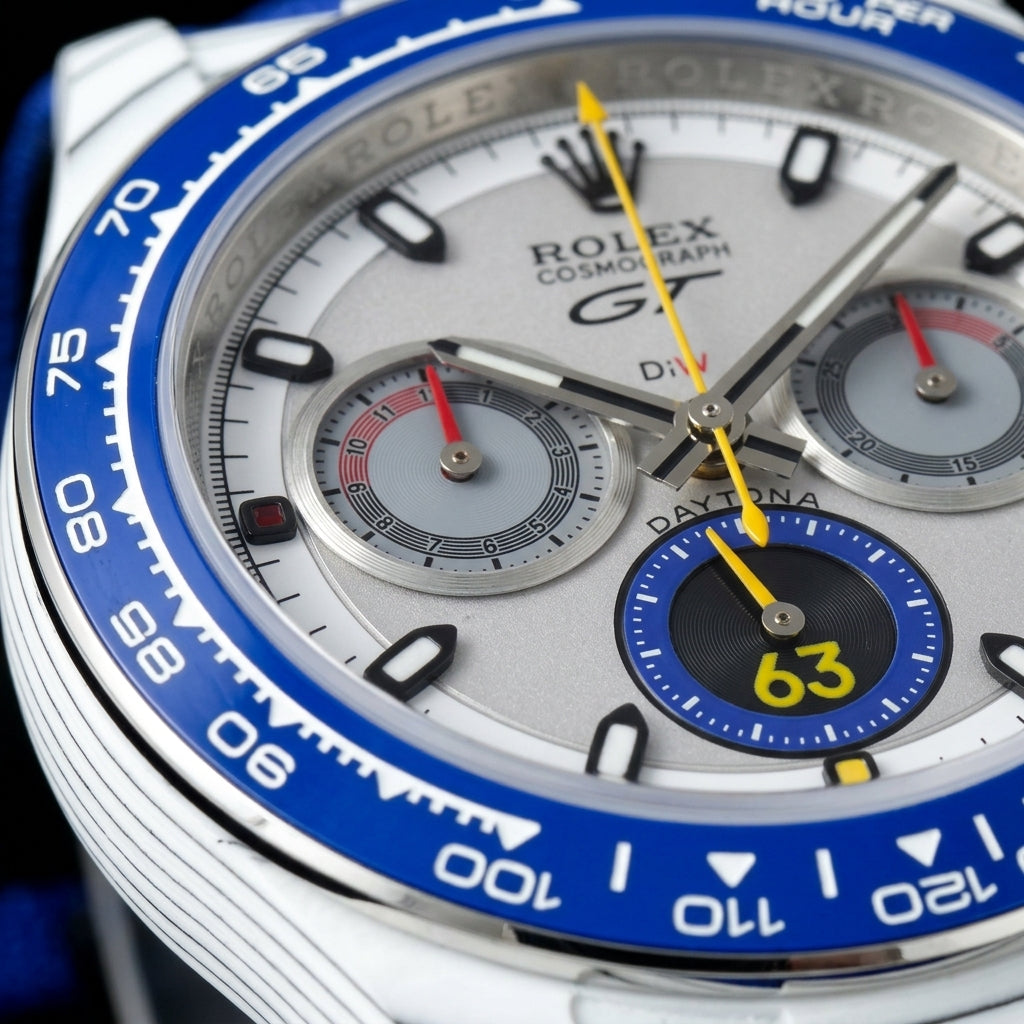 Macro of the silver-grey dial with the blue-ringed yellow 63 counter, two grey counters with red hands and the yellow chronograph hand
