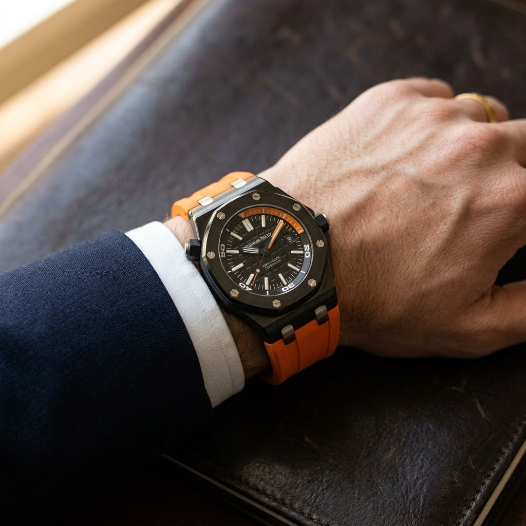 Black ceramic diver on an orange rubber strap worn under a navy suit cuff